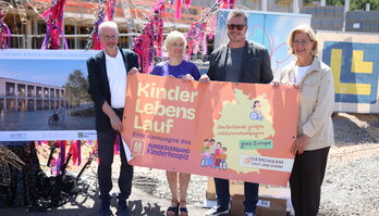 Ehrengäste mit Plakat zum Kinderlebenlauf
