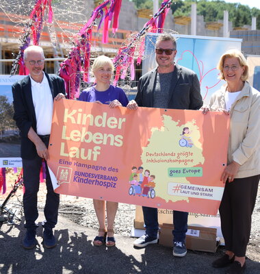 Ehrengäste mit Plakat für den Kinderlebenslauf
