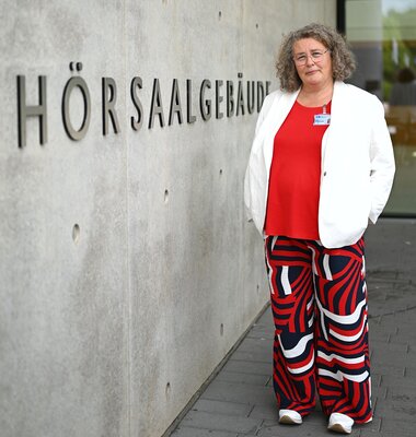 Pflegewissenschaftlerin vor Hörsaalgebäude