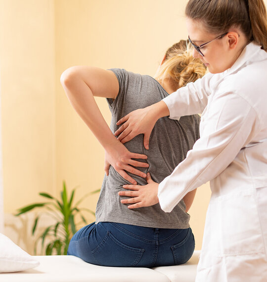 Ärztin untersucht die Beweglichkeit einer Patientin