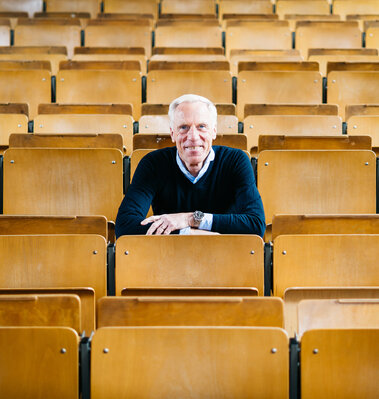 Prof. Dr. Ingo Froböse sitzt in einem Hörsaal