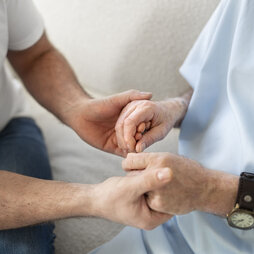 Parkinsonpatient hält Hand einer Angehörigen