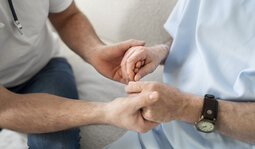 Parkinsonpatient hält Hand einer Angehörigen